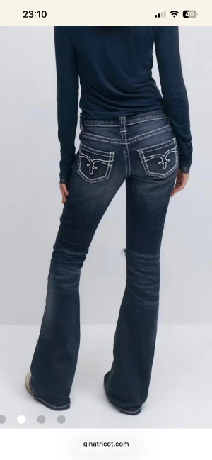 Bootcut jeans med slitningar från Gina Tricot - Säljer helt nya Mörkblå bootcut jeans med slitningar och  hål på benen då jag räknat köpa fel storlek jeansen är väldigt små i storleken men ändå perfekt för dig som gillar en retro vibe. Ny pris 299