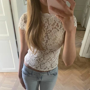 Vit spets topp!!💞 - Supersöt vit topp i spets  med blommigt mönster och korta ärmar. Toppen är figurnära och har en snygg croppad passform.  Den är ifrån Zara och är i storlek S!!🫰🏻