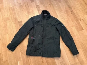 SNOOT, jacka, olivgrön, khaki, polyester, storlek M - Olivgrön militär/utility-jacka från Snoot i storlek medium. I mycket gott skick. Passar kallare vårdagar eller mildare höstdagar - lager på lager gäller. Jackan är utrustad med flera fickor med plats för mobil, hörlurar mm. Har även en karbinhake för att fästa nycklar, plånbok eller liknande.  Bröstmått (armhåla till armhåla): 112 cm. Längd (krage till fåll): 74 cm.  Vid frågor kontakta mig gärna via chatt eller email.