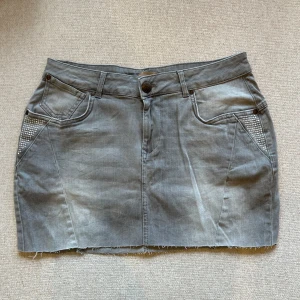 Grå jeanskjol med stenar från Zizzi - Supersnygg jeanskjol från Zizzi i storlek S. Perfekt nu till sommaren, avklippt, har massa stenar som snygga detaljer!❤️