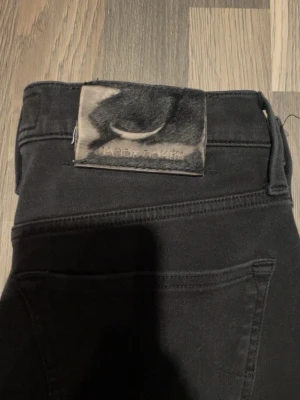 Jacob Cohën jeans  - Säljer ett par svarta jeans från Jacob Cohën i storlek 28. Byxorna har klassisk femficksdesign, raka ben och är tillverkade i ett mjukt bomullsmaterial med stretch. Snyggt Jacob Cohën-märke baktill och italiensk design. Perfekta för en stilren look. L32/W28 kostar typ 7000 nya