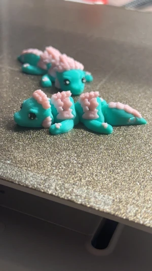 1st 3D-Printad Mintgrön och Rosa drake i nyckelring - Perfekt julklapp inför Julen!  En extremt unik nyckelring i form av en mini drake Draken är flexibel och går att vicka på sig  Kan användas för att hänga på väskor eller nycklar men det går även att leka med den utan att behöva sätta den på något!  Den är ca 6.5cm lång