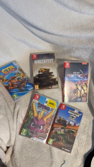Nintendo Switch spelpaket (5 spel) - Fem Nintendo Switch-spel: Crash Team Racing Nitro-Fueled, Wreckfest, Star Trek Prodigy: Supernova, Spyro Reignited Trilogy och Monster Jam Steel Titans. Alla fodral ser ut att vara i gott skick, perfekta för spelsamlaren eller familjen.