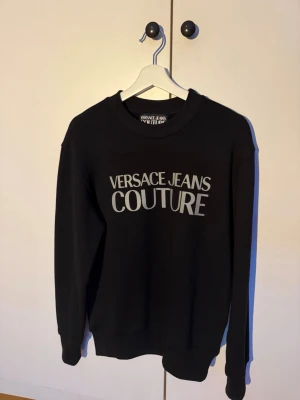 Svart sweatshirt Versace Jeans Couture - Sweatshirt från Versace Jeans Couture. Storlek XS men passar även small. Skick 9/10 väldigt sparsamt använd. Kvitto och tags medföljer från butik. Pm vid intresse🤝