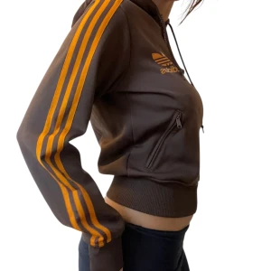 Adidas kofta - En brun adidas kofta med orangea detaljer!🧡 Den har både luva och fickor, är i väldigt bra kvalité och har en snygg passform 😮‍💨