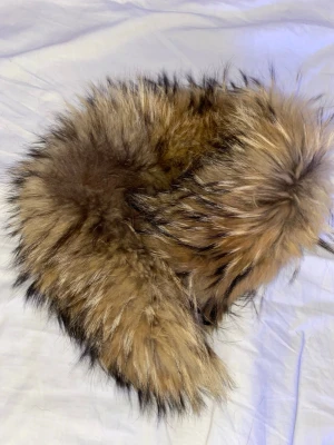 Brun fluffig pälsvästkrage - köpt pp Alexandra Triangeln för 2000kr. Supermjuk och fluffig pälsvästkrage i bruna och beige toner med svarta inslag. Perfekt att slänga över en jacka eller tröja för extra edge. Naturlig look med långhårig päls och cool volym. Ingen synlig branding.