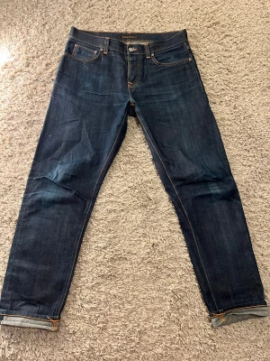 Nudie Jeans Steady Eddie II Dry Selvage - Tja säljer nu dessa sjukt snygga Nudie dry selvage jeansen i grymt skick👖😻 Jeansen har börjat få lite fades i men som kommer bli mycket bättre med tiden👌🏼| Storleken är W32 L32 och modellen heter ”Steady Eddie ll”✅ | Vid frågor är det bara att skriva 🤝🏼🤩