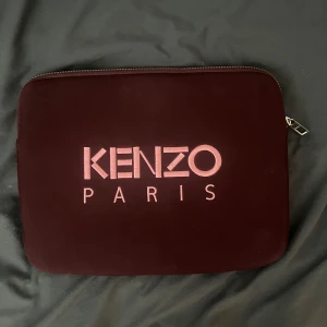 datorväska från Kenzo - Säljer en vinröd datorfodral från Kenzo med tigerbroderi på ena sidan och Kenzo Paris-logga på andra. Datorn är en MacBook Air och passar perfekt för fodralet. Liten fläck på framsidan men syns knappt. Nypris:1000kr