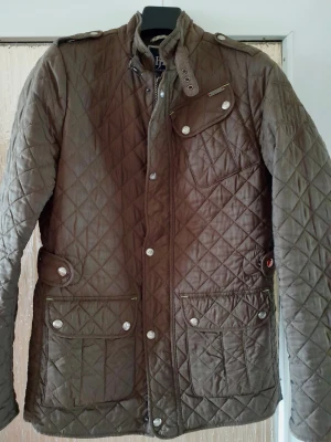 Quiltad olivgrön jacka - Hansen & Jacob -S - Hansen & Jacob -  Olivgrön quiltad jacka. - Stl S Utmärkt skick - Förvarad i garderob  Passform normal S. Kan ses som 46 eller mindre 48. Kan justeras i midjan med knapparna.  Djur och rökfritt hem.