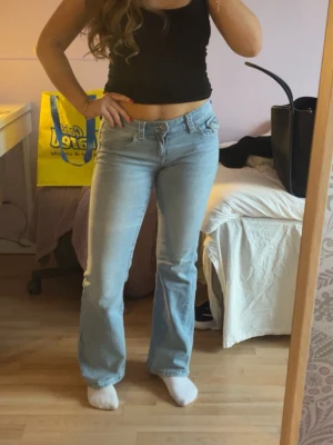 Ljusblå bootcut jeans med fickdetaljer - Säljer ett par ljusblå jeans med bootcut-modell och snygga fickdetaljer bak. Använda 2 gånger. 