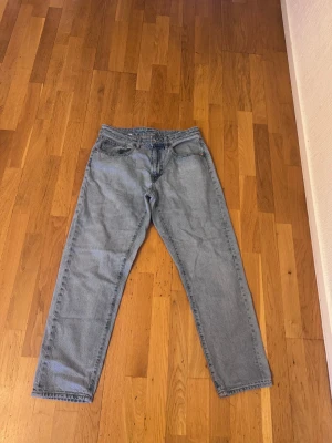 Levi's 501 ljusblå jeans straight fit - Klassiska Levi's 501 jeans i ljusblå tvätt med rak passform. Modellen har fem fickor, knapp och dragkedja i gylfen samt bälteshällor. Jeansen är tillverkade i slitstarkt bomullsjeans och har en tidlös look som funkar till allt. Knappt använda 