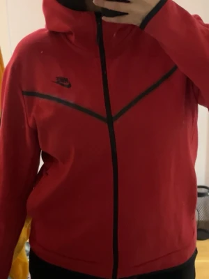 Nike Tech Fleece  - En röd Nike tech fleece, använd ett par få antal gånger sedan bara haft den upphängd. Inga fel på den, i väldigt bra skick! Pris kan diskuteras! 