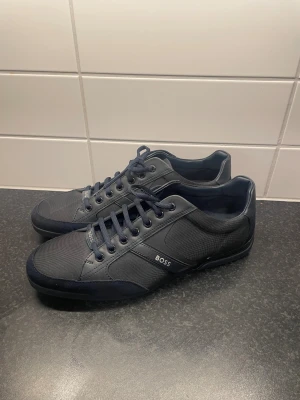  BOSS sneakers Saturn - Det är ett par helt nya Hugo boss skor med modellen Saturn. Storlek 44.  Aldrig använda på grund av fel storlek, som du ser. Ny pris låg på runt 1400kr. Priset är inte hugget i sten, vid snabb affär. Skicka alltid vid frågor.