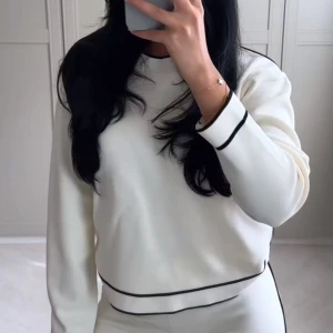 Vit tröja med svarta detaljer  - Snygg vit tröja från Mango med svarta ränder vid hals, ärmslut och nederkant. Långärmad och i mjukt material som känns skönt mot huden. Perfekt för dig som gillar en clean och stilren look. Använd max 2 ggr💞💞