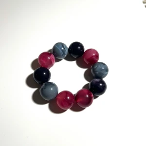 pärlarmband med stora kulor - Säljer ett coolt armband med stora, runda pärlor i rosa, blå och svart. Pärlorna har en marmorerad effekt som ger ett unikt och trendigt utseende🩷