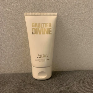 Jean Paul Gaultier Divine Body Lotion - Body lotion från Jean Paul Gaultier Divine i en vit tub med guldfärgad text. Tuben är 75 ml och knappt ens använd då ja inte brukar använda hudkrämer med doft. (Fick den i present) Möts gärna upp vid köp och tar endast emot kontant då jag inte kan ta emot Swish för tillfället