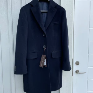 Marinblå rock från Oscar Jacobson - Stilren marinblå rock från Oscar Jacobson. Ny skick, lappar sitter kvar. Storlek 46 vilket motsvarar S men passar även M. Ny pris är 5500kr och mitt pris är 2300kr. Hör av dig vid minsta lilla fundering eller fråga!