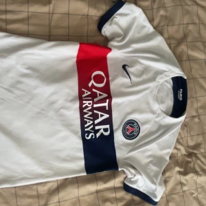 PSG vit matchtröja Nike Qatar Airways - Snygg PSG fotbollströja i vitt med breda röda och mörkblå ränder över bröstet. Säljer för 500 priset kan diskuteras 