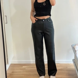 Svarta raka byxor i skinnimitation NA-KD - Snygga svarta byxor från NA-KD i skinnimitation med raka ben!