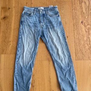 Loose fit jeans från Jack & Jones - Snygga ljusblå jeans från Jack & Jones i loose fit-modell. Klassisk femficksdesign med knappgylf och slitna detaljer. Jeansen är tillverkade i bomull och har en avslappnad passform som ger en chill vibe. Perfekta för dig som gillar en lite baggy stil.