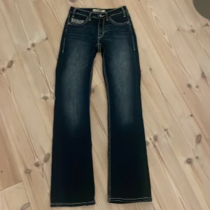 Rock & Roll bootcut jeans  - Mörkblå bootcut jeans från Rock & Roll med snygga broderade bakfickor och kontrastsömmar. Midwaist 