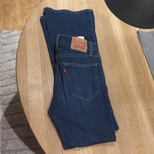 Levi's 726 Flare jeans blå, stl 25 - Snygga Levi's 726 Flare jeans i klassisk mörkblå denim. Modellen har utsvängda ben och femficksdesign med Levi's ikoniska röda etikett på bakfickan. Perfekta för dig som gillar en retroinspirerad look med modern twist. Pris går att diskutera! 