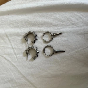 Edblad silver örhängen  - Säljer två par silvriga örhängen från edblad. Ett par är hoops med spetsiga konformade spikes, det andra paret är hoops med flera små nitar runt hela ringen. Säljer de i andra annonser så man kan köpa var för sig