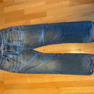 Blå jeans från G-Star RAW, W34 L32 - Säljer ett par klassiska blå jeans från G-Star RAW. Jeansen har fyra fickor, bruna sömmar och G-Star-logga på bakfickan. 