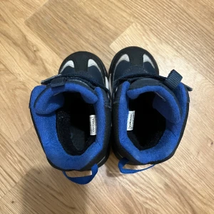 Blå vinterboots från Viking strl 22 - Snygga vinterboots från Viking i marinblått och svart med vita detaljer. Skorna har grov sula för bra grepp, kardborreband och är fodrade med blått tyg för extra värme. Perfekta för kalla dagar och lek utomhus.