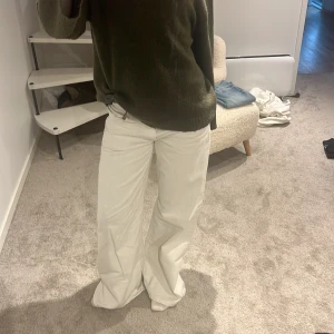 Vita wide jeans med låg midja - Säljer ett par vita jeans med låg midja och breda ben. Byxorna har klassisk femficksdesign och är i ett mjukt bomullsmaterial. Perfekta för dig som gillar en avslappnad och trendig look.