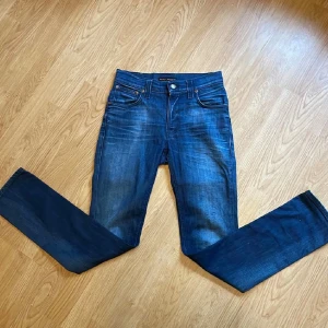 Feta Blå Nudie jeans L32 W28 - Nästan helt nya Nudie byxor med inga syngliga täcken av användning. Subtila och stilliga slitningar. Super skönna, säljer då dom inte passar och kunde inte lämna tillbaka. Kontakta för mer info. Det är thinn finn model.