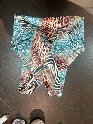 Leopardmönstrad tubtopp från SHEIN - Säljer en tubtopp från SHEIN i storlek XS med ett färgstarkt leopard- och zebramönster i turkos, brun och beige. Materialet är mjukt och stretchigt polyester. Helt oanvänd och ny.