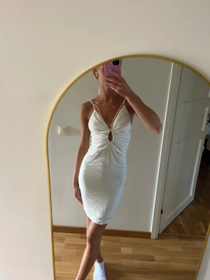 Vit kort klänning med smala band - Säljer en vit kort klänning med smala axelband & v-ringning. Klänningen har en snygg rynkning framtill & en liten cut-out under bysten. Figurnära passform och perfekt för sommarens alla tillfällen. Klänningen är ifrån H&M & har tyvärr aldrig kommit till användning av mig (prislappen kvar). Storlek XS🤍