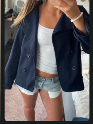 Blå kappa från Zalando - Säljer en as snygg stilren marinblå kappa pga ingen användning. Den har tillhörande knappar och fin passform. Skön och mjuk perfekt för både kallare och varmare dagar. 