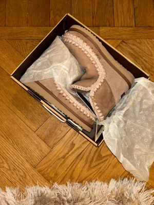 Beigea Mou boots  - Säljer ett par beige boots från Mou i mjuk mocka med grov stickad kant runt öppningen och längs sulan💕Modellen eskimo 18 i färgen pink brown, nypris 2500 kr från Mous hemsida 
