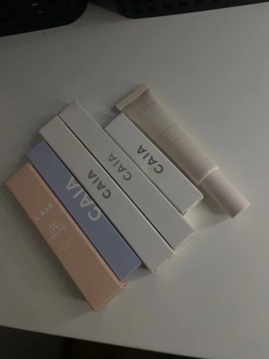 CAIA sminkkit med primer och gel - Säljer ett sminkkit från CAIA med fem produkter i snygga pastell- och vita förpackningar. Innehåller All Eyes On Me ögonskuggsprimer i ljusrosa, deras vattenfasta mascara och deras serum mascara, deras lip primer, samt Super Sleep brow lamination gel i beige tub. Perfekt för att fixa bryn och ögon. Alla produkter är oanvända.