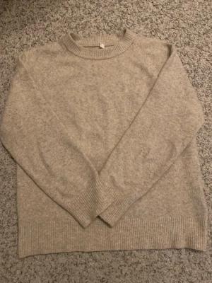 Beige stickad tröja från Uniqlo - Säljer en enkel och snygg beige stickad tröja från Uniqlo. Tröjan har rund hals, långa ärmar och ribbade muddar vid ärmslut och nederkant. Materialet är en mix av akryl, polyamid, bomull och elastan för en mjuk och skön känsla.