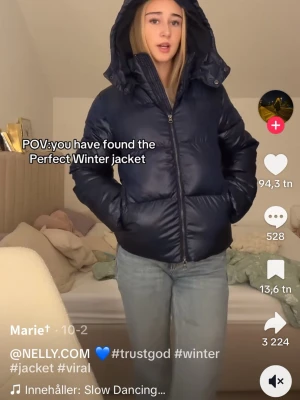 Mörkblå pufferjacka med huva - Säljer en mörkblå pufferjacka från Nelly med stor, mysig huva och dragkedja framtill. Jackan har en schysst oversized passform och är perfekt för kalla vinterdagar. Den har två fickor på sidorna och en clean look som funkar till jeans eller andra outfits.