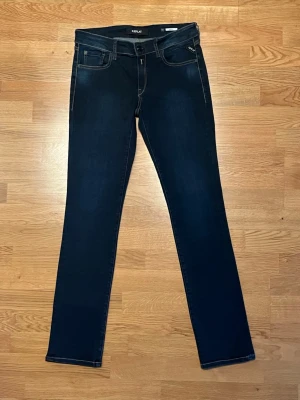 Replay jeans straight fit - Snygga mörkblå jeans från Replay med klassisk femficksdesign och raka ben. Jeansen har kontrastsömmar och läderpatch bak i midjan. Perfekt passform med normal midja och tillverkade i mjukt denimtyg för en bekväm känsla.