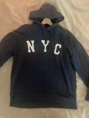Hoddie - En mysig marinblå hoddie i storlek m, där det står NYC.
