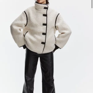 Vit teddyjacka med svarta detaljer - Intressekoll på min fina teddy jacka, helt slutsåld, använd sparsamt och är i bra skick! Storlek M men passar S oxå