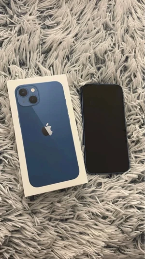 iPhone 13 -  iPhone 13 blå. Telefonen fungerar helt utan problem och är nollställd och redo att användas. Den har använts normalt och allt fungerar som det ska kamera, skärm, Face ID, knappar och högtalare. Har en djupare repa på skärmen, liten skada nere på ramen samt några vita prickar på sidan (syns på bild) – endast kosmetiska. Det påverkar ej funktionen eller användningen.  	•	Modell: iPhone 13	•	Lagring: 128GB 	•	Batterihäsa: 79%.  ( kartong ingår.  skal om man önskar) • OLÅST 