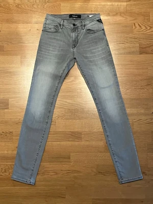 Replay jeans W27 L32 - Snygga ljusgrå skinny jeans från Replay med klassisk femficksdesign och dragkedjegylf. Jeansen har en smal passform och är tillverkade i stretchigt denim för extra komfort. Perfekta för dig som gillar en modern och stilren look.