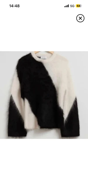 Svartvit fluffig stickad tröja - Säljer en stickad tröja från other storis med ett coolt svartvitt mönster i diagonal design. Tröjan är i mohair och i ny skick ( använd 1-3 gånger)  och har långärmade ärmar samt rund hals. Perfekt för dig som gillar statement-plagg och vill ha något mjukt och skönt.