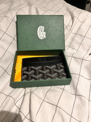 Svart plånbok med grön G box - Svart plånbok med mönster och en grön G box 