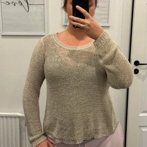 Beige stickad tröja  - Säljer en beige stickad tröja med rundad hals och långärmade ärmar. Tröjan har en grovstickad struktur och avslappnad passform, perfekt för att slänga på sig när det är lite kyligt. Enkel och stilren design som är lätt att matcha med olika outfits.