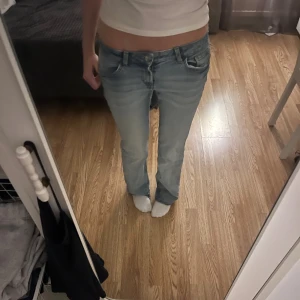 Ljusblå bootcut jeans låg midja - Säljer ett par ljusblå jeans med bootcut passform och låg midja. Klassisk femficksmodell med snygga slitningar och raka ben. Perfekta för dig som gillar en avslappnad och retro vibe. Säljer då de är snäppet för stora för mig. Skriv om ni har några funderingar ❤️🥰