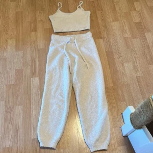 Mjukisset  - Mysig beige topp med smala axelband och ribbad nederkant. Toppen är i ett mjukt material som känns skönt mot huden och passar perfekt till avslappnade dagar hemma.