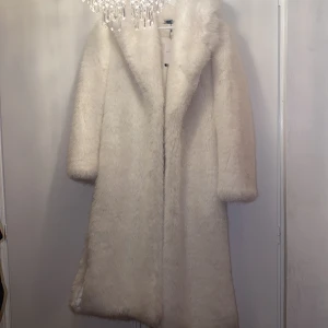 Vit lång pälsjacka  - Aldrig använd, endast testat, prislapp finns kvar. Storlek XS. Fin vit pälsjacka (inte riktig päls) 