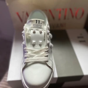 Valentino Rockstud Untitled sneakers vit - Snygga vita Valentino Rockstud Untitled sneakers med ikoniska pyramidnitar och rund tå. Storlek 39 men passar 38.  Helt nya och boxen är med. Priset är inte hackat i sten!